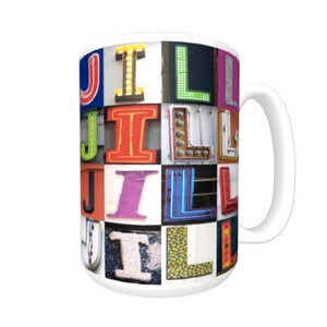 May include: White ceramic mug with a colorful design featuring the letters "JILL" made up of various colorful and patterned letters. The letters are arranged in a grid pattern.