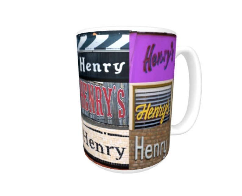 Op de afbeelding: Witte keramische mok met een kleurrijke collage van de naam "Henry" in verschillende lettertypen en stijlen. De mok heeft een zwart handvat.