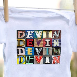 Può includere: Un body bianco per neonato con una grafica colorata del nome "DEVIN" scritto in un font a blocchi. Ogni lettera è composta da diversi motivi e texture colorati.