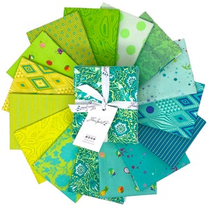 May include: A set of 16 green and blue fabric squares featuring a variety of patterns, including geometric designs, floral prints, and abstract shapes. The fabric squares are arranged in a circle and tied together with a white ribbon. The label on the ribbon reads "Free Spirit".
