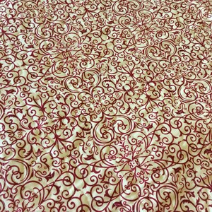 Puede incluir: Tela color crema con un patr&oacute;n repetitivo de volutas y dise&ntilde;os florales burdeos. El patr&oacute;n se distribuye uniformemente por la superficie, creando una textura visualmente rica y detallada. La tela parece estar acolchada.