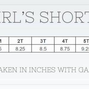 May include: A size chart for girl's shorts, with waist measurements in inches. Sizes range from 12M to 10, with waist sizes from 7.5 to 11.5 inches. The text "GIRL'S SHORTS" is at the top. The text "MEASUREMENTS ARE TAKEN IN INCHES WITH GARMENT LYING OUT FLAT" is at the bottom.