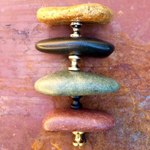 Peut inclure: Quatre boutons en pierre empil&eacute;s avec des accents en laiton et en argent. Les boutons sont dans des tons de brun, noir, vert et rouge.