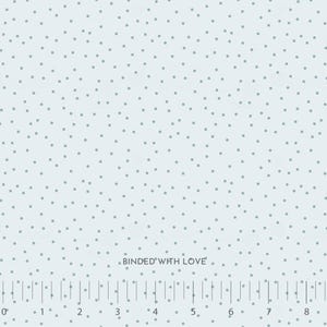 May include: Light blue fabric with a scattered dot pattern. The dots are a muted gray color. The text "BINDED WITH LOVE" is printed on the fabric. A ruler is printed along the bottom edge of the fabric.