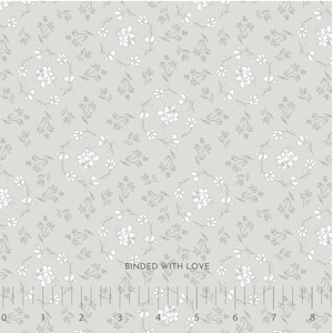 May include: A light green fabric with a delicate floral pattern. White flowers and small leaves are arranged in a repeating design. The text "BOUNDED WITH LOVE" is printed on the fabric. The fabric has a ruler printed along the bottom edge.