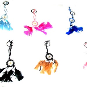 May include: A collection of dreamcatcher keychains in various colors. Each keychain features a small dreamcatcher with a circular design, feathers, and a metal ring for attachment. Colors include blue, pink, black, and orange.