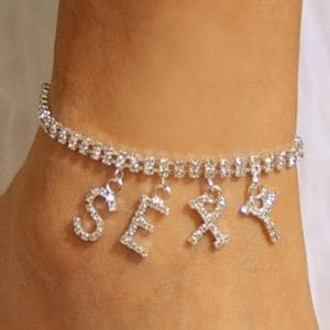 May include: A silver rhinestone anklet spelling out the word "SEXY". The anklet is made of small, sparkling rhinestones set in a silver metal band. The letters dangle from the band.