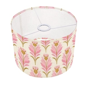 May include: A pink and gold floral patterned lampshade with a white interior.