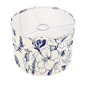 May include: A white lampshade with a blue floral pattern. The pattern features stylised flowers and leaves.