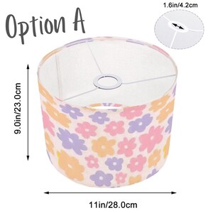 Pode incluir: Um abajur branco com um padr&atilde;o floral em rosa, laranja e roxo. O abajur tem 23 cm de altura e 28 cm de largura. Op&ccedil;&atilde;o A.