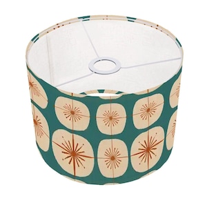 May include: A teal blue lampshade with a white background and a repeating pattern of orange starbursts inside beige squares.
