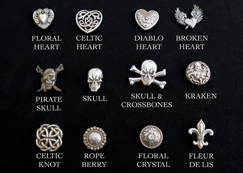 May include: A collection of 12 silver-toned metal buttons with various designs, including hearts, skulls, and knots. The buttons are arranged in four rows of three, with each button labeled with its name below it.