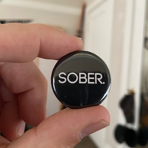 May include: A black button with the word "SOBER." printed in white.