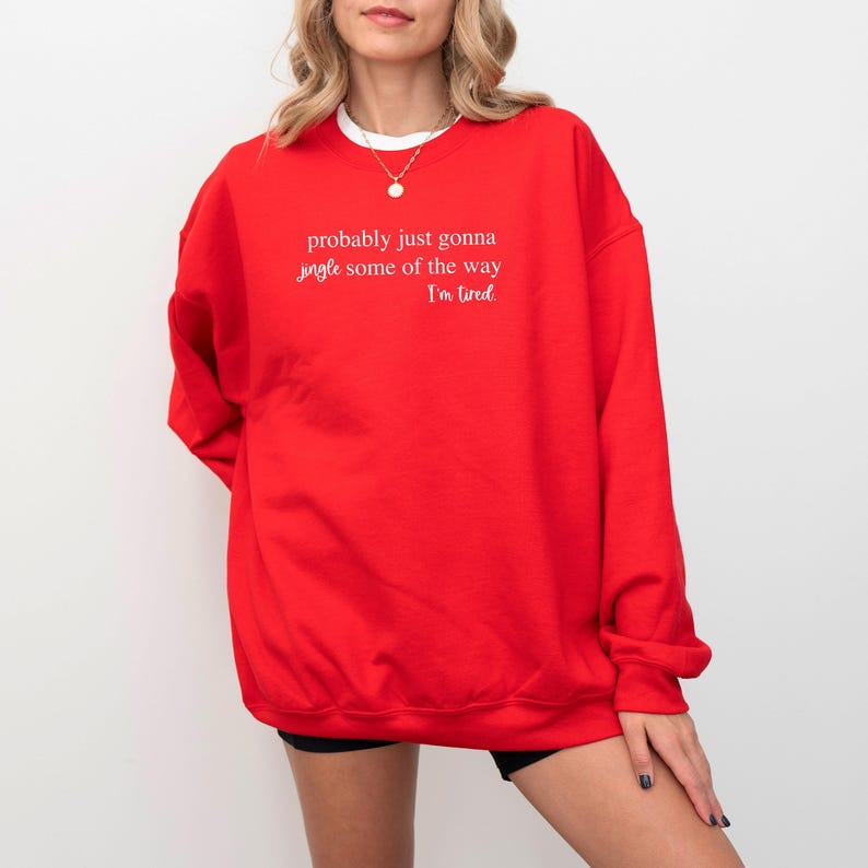 May include: A bright red sweatshirt with the text "probably just gonna jingle some of the way I'm tired" in white. The sweatshirt is a crew neck style and appears to be made of a soft material.