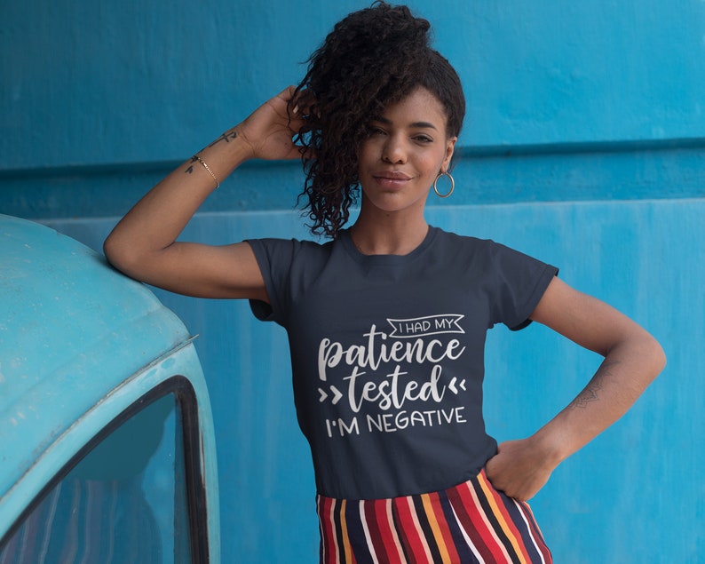 Puede incluir: Una camiseta azul marino con texto blanco que dice "Tuve mi paciencia >probada< Soy negativa".