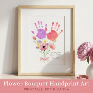 Peut inclure: Une impression encadrée présentant une illustration à l'aquarelle de deux empreintes de mains en violet et orange, disposées en bouquet de fleurs avec des tiges vertes et un nœud rose. Le texte indique Hand-picked for you, with love, Olivia & Noah.