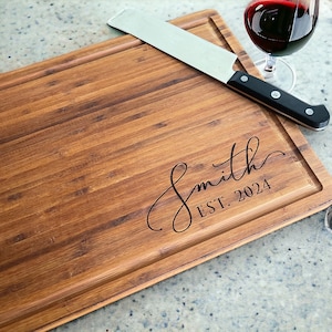 May include: A brown wooden cutting board with a knife and the text "Smith EST. 2024" engraved on it.