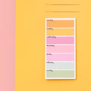 May include: A colorful weekly planner with days of the week labeled: Monday, Tuesday, Wednesday, Thursday, Friday, Saturday, and Sunday. Each day is represented by a different color.
