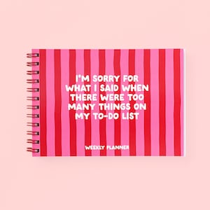 May include: A spiral-bound weekly planner with a pattern of vertical red and pink stripes. The cover features white text that reads: I'M SORRY FOR WHAT I SAID WHEN THERE WERE TOO MANY THINGS ON MY TO-DO LIST and the words WEEKLY PLANNER.