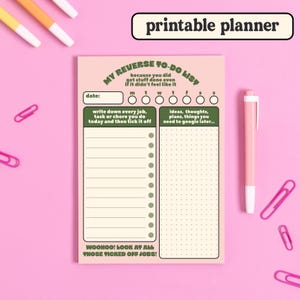 Puede incluir: Un planificador imprimible con fondo rosa y detalles verdes. El planificador tiene una secci&oacute;n para escribir tareas y una secci&oacute;n para ideas. El texto en el planificador dice "My Reverse To-Do List" y "Woohoo! Look at all those ticked off jobs!"