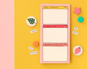 May include: A pink to-do list notepad with three sections labeled "bare minimum", "if there's time", and "absolutely smashing it". Each section has a blank space for writing and a small red circle for marking tasks as done. The notepad is on a yellow surface with various colorful stickers and small paper notes.