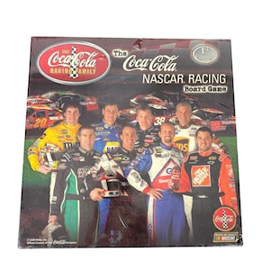 May include: A Coca-Cola NASCAR Racing board game. The box features a collage of race car drivers and race cars. The Coca-Cola Racing Family logo is at the top left. The game is a 1st Edition.