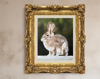 Puede incluir: Pintura al óleo de un conejo en un marco dorado ornamentado. El conejo está representado en tonos marrones, blancos y grises, con orejas largas y una cola esponjosa. El fondo es verde oscuro y negro. El marco es detallado, de estilo antiguo.