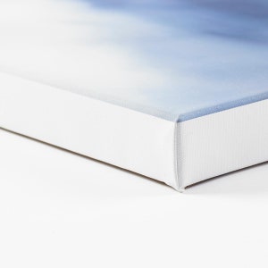 May include: Close-up of the edge of a white canvas print. The canvas is wrapped around the edges of the frame, creating a clean and finished look.