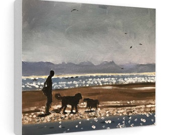 May include: Canvas art print of a beach scene with a person and two dogs. The painting features a person standing on the sand with two black dogs. The sky is gray with a few birds flying. The ocean waves are white and blue.