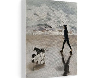 May include: A painting of a person walking a dog on a beach. The person is wearing a dark jacket and pants. The dog is black and white and is running ahead of the person. The background is a cloudy sky and the ocean.