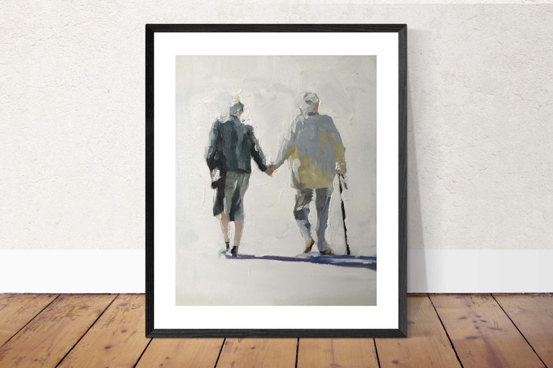 May include: Framed art print depicting two figures walking hand-in-hand, viewed from behind. The figures are painted in muted tones of gray, blue, and yellow, with a white background. One figure uses a cane. The artwork is in a black frame.