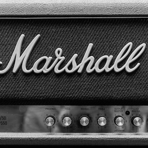 May include: A black and white image of a Marshall guitar amplifier with the text "Marshall" in white lettering on the front. The amplifier has a series of knobs for adjusting the sound, including presence, bass, middle, treble, output master, lead master, and input gain.