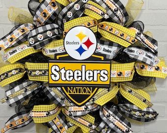 Könnte beinhalten: Ein schwarz-gelber Steelers-Kranz mit schwarz-weißem kariertem Band, gelbem Band mit schwarzen Steelers-Logos und einem großen Steelers-Logo mit den Worten "Steelers Nation".