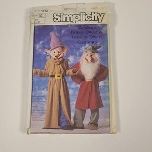 May include: A vintage Simplicity sewing pattern featuring Disney's Dopey Dwarf and Grumpy Dwarf costumes. The pattern shows illustrations of the characters in their outfits. The packaging is slightly worn, with the Simplicity logo and text visible.