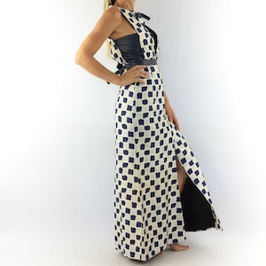 May include: A long white and blue checkered dress with a black leather bodice and a side slit. The dress has a tie at the waist.