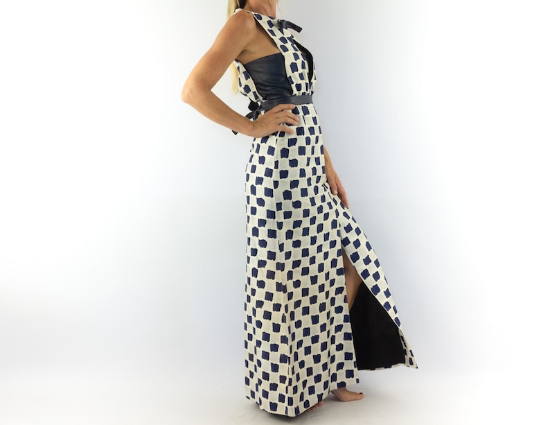 May include: A long white and blue checkered dress with a black leather bodice and a side slit. The dress has a tie at the waist.