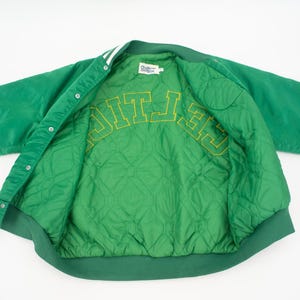 May include: Green satin varsity jacket with a quilted lining and "CELTICS" embroidered in yellow on the inside.