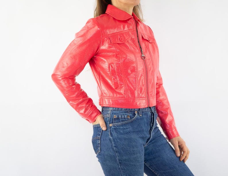 May include: A bright red cropped leather jacket with a zipper closure and a collared neckline.