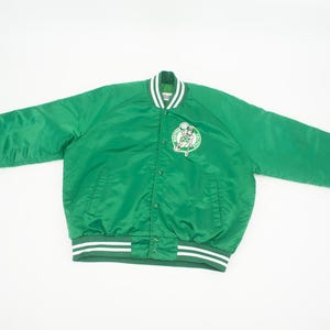 May include: Green satin bomber jacket with white and green striped cuffs and waistband. The jacket features a large Boston Celtics logo on the front.