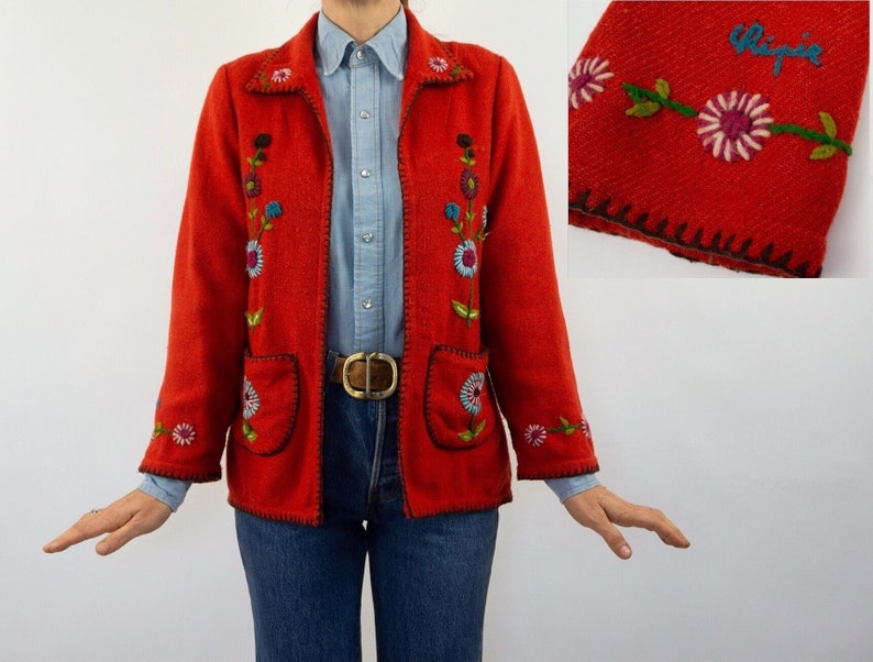 May include: Red embroidered jacket with floral details and a black belt. The jacket has a label that says "Chipie".