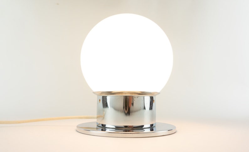 May include: A white globe lamp with a chrome base and a round chrome base.