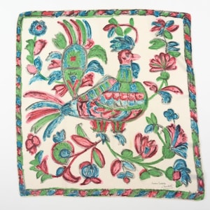 Könnte beinhalten: Quadratisches Seidentuch mit einem farbenfrohen Vogel- und Blumendesign. Der Vogel weist rote, grüne und blaue Farbtöne auf, umgeben von rosa und blauen Blumen auf cremefarbenem Hintergrund. Der Rand ist eine Mischung aus Grün, Rot und Blau.