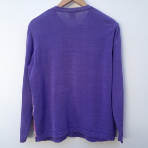 May include: A long-sleeved shirt in a solid purple color. The shirt has a crew neck and is made of a soft, comfortable fabric.
