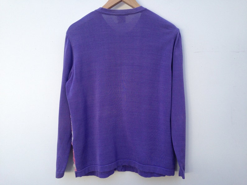 May include: A long-sleeved shirt in a solid purple color. The shirt has a crew neck and is made of a soft, comfortable fabric.