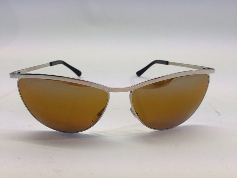 May include: Silver cat-eye sunglasses with brown lenses.