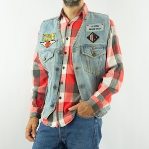 May include: Light blue denim vest with Harley Davidson patches and a red and black plaid shirt. The vest has two front pockets and button closures. Patches include "Hall Melon" and "IS WING INDIAN RALLY".