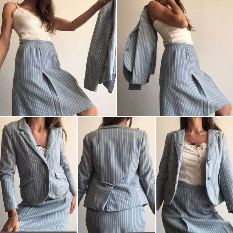 Puede incluir: Un traje de falda azul claro a rayas finas, compuesto por una chaqueta y una falda. La chaqueta tiene un cuello de muesca y un cierre de un solo bot&oacute;n. La falda es de l&iacute;nea A y tiene una cremallera lateral.