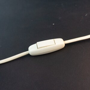 May include: A white inline on/off switch with a white cord attached.