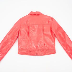 May include: A bright pink faux leather jacket with a button-up front and long sleeves.