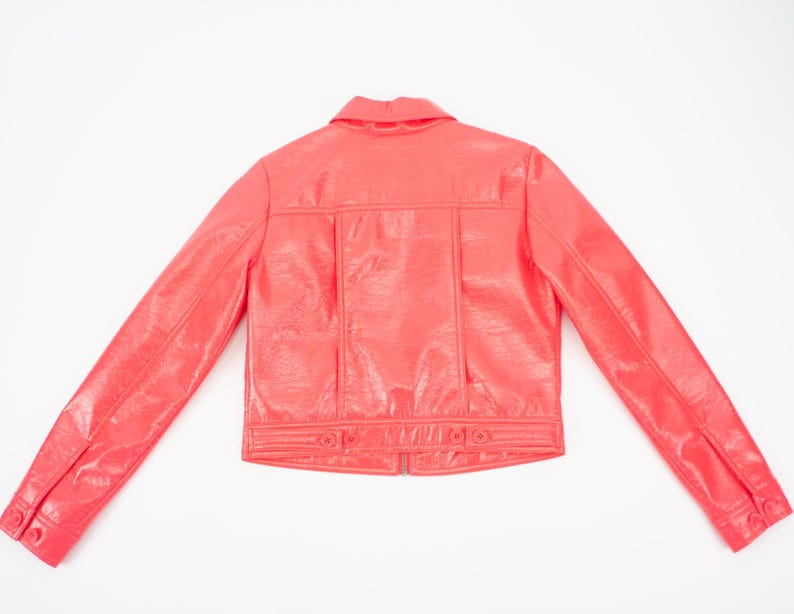 May include: A bright pink faux leather jacket with a button-up front and long sleeves.